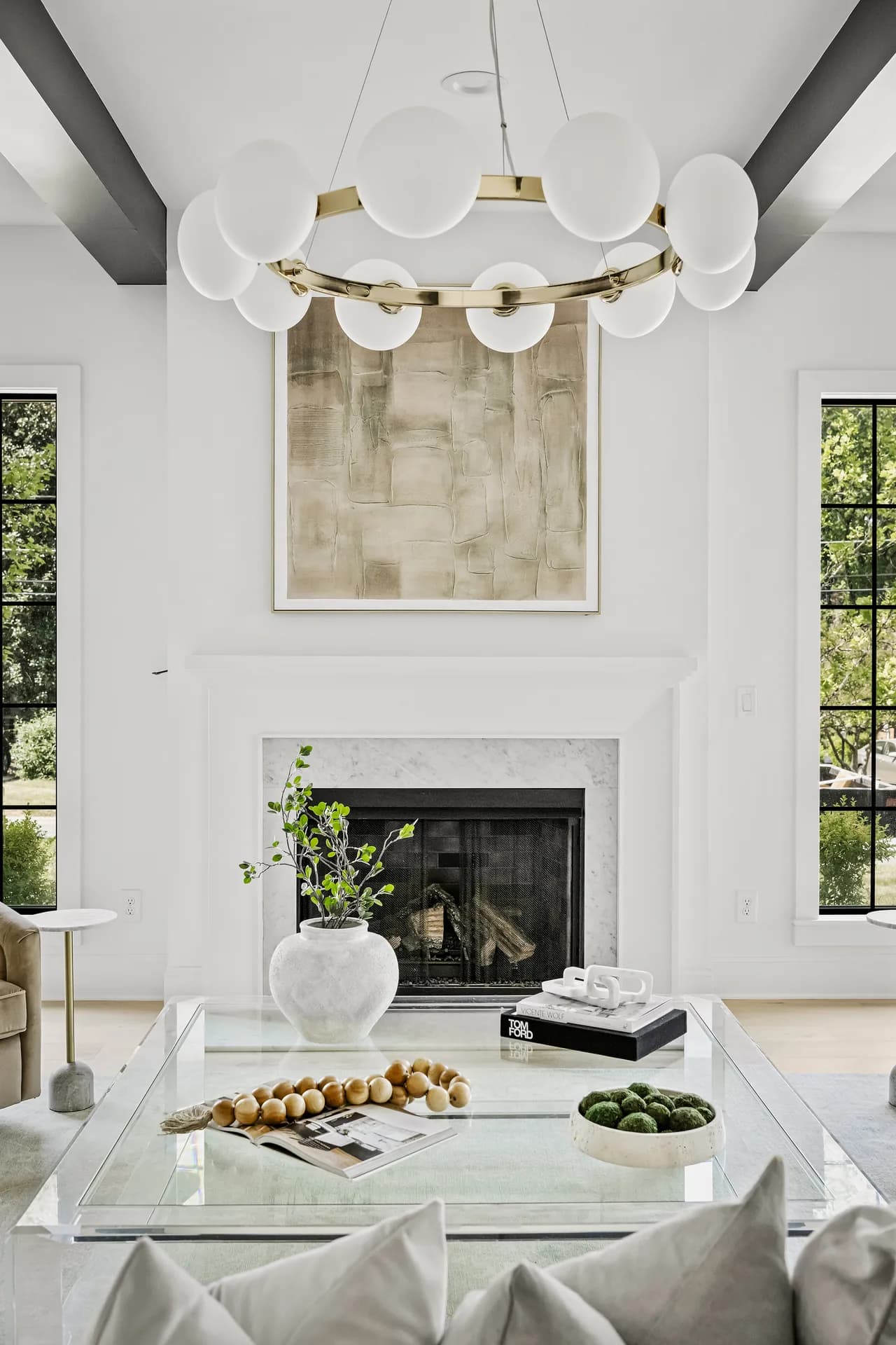 Double-height living room detail with a circular brass light and white fireplace.